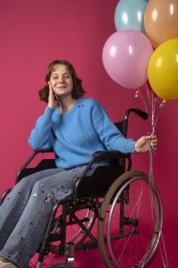 portrait of disabled woman in a wheelchair with balloons