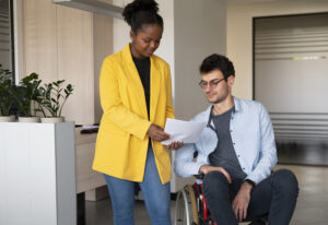 NDIS appeals officer assisting a person with disability using a wheelchair